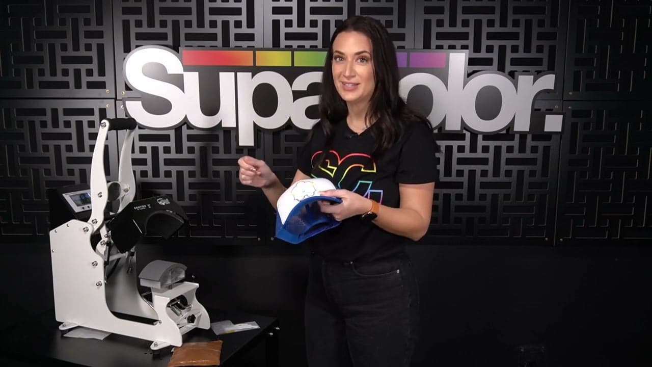 Woman demonstrates pressing Supacolor headwear transfers on trucker cap using heat press machine