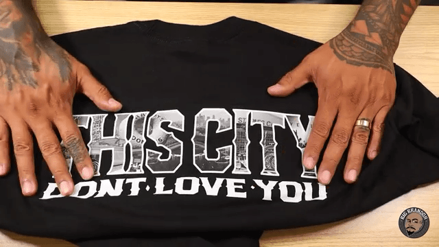 Hands displaying photo realistic transfer graphic on black t-shirt for Supacolor product demonstration